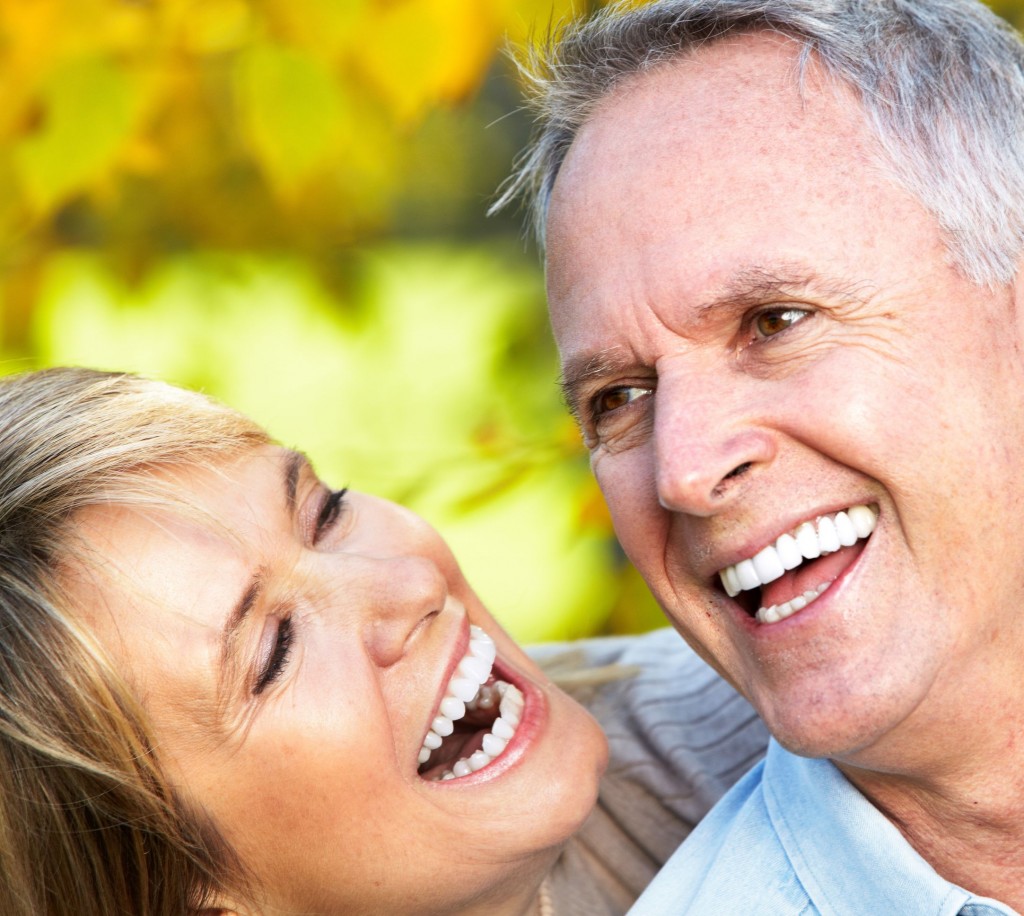 Two mature couple smiling showing their teeth